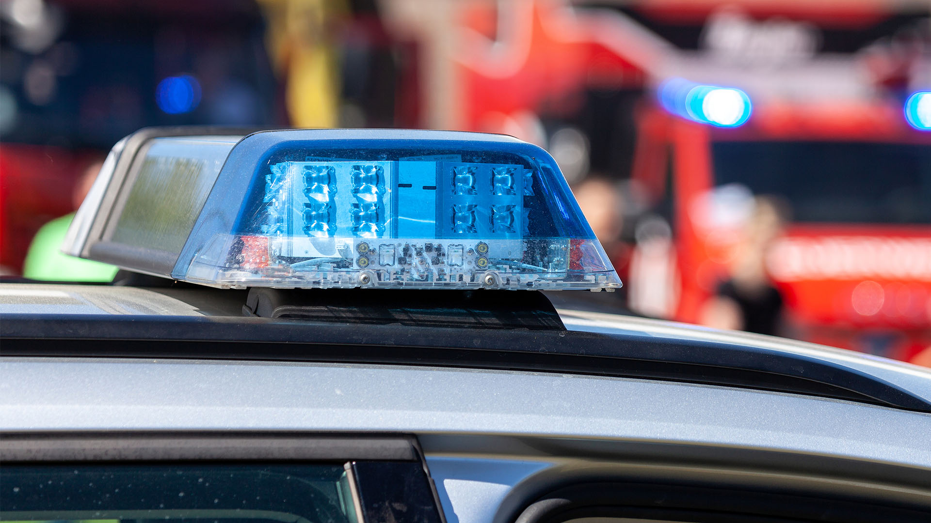 Streifenwagen der Polizei und Feuerwehr mit Blaulicht