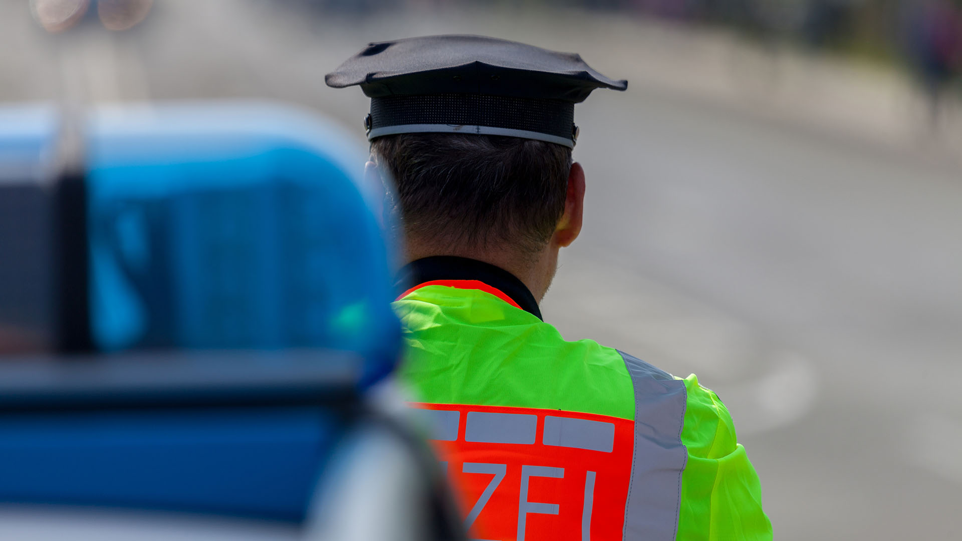 Blaulicht und Polizist von hinten