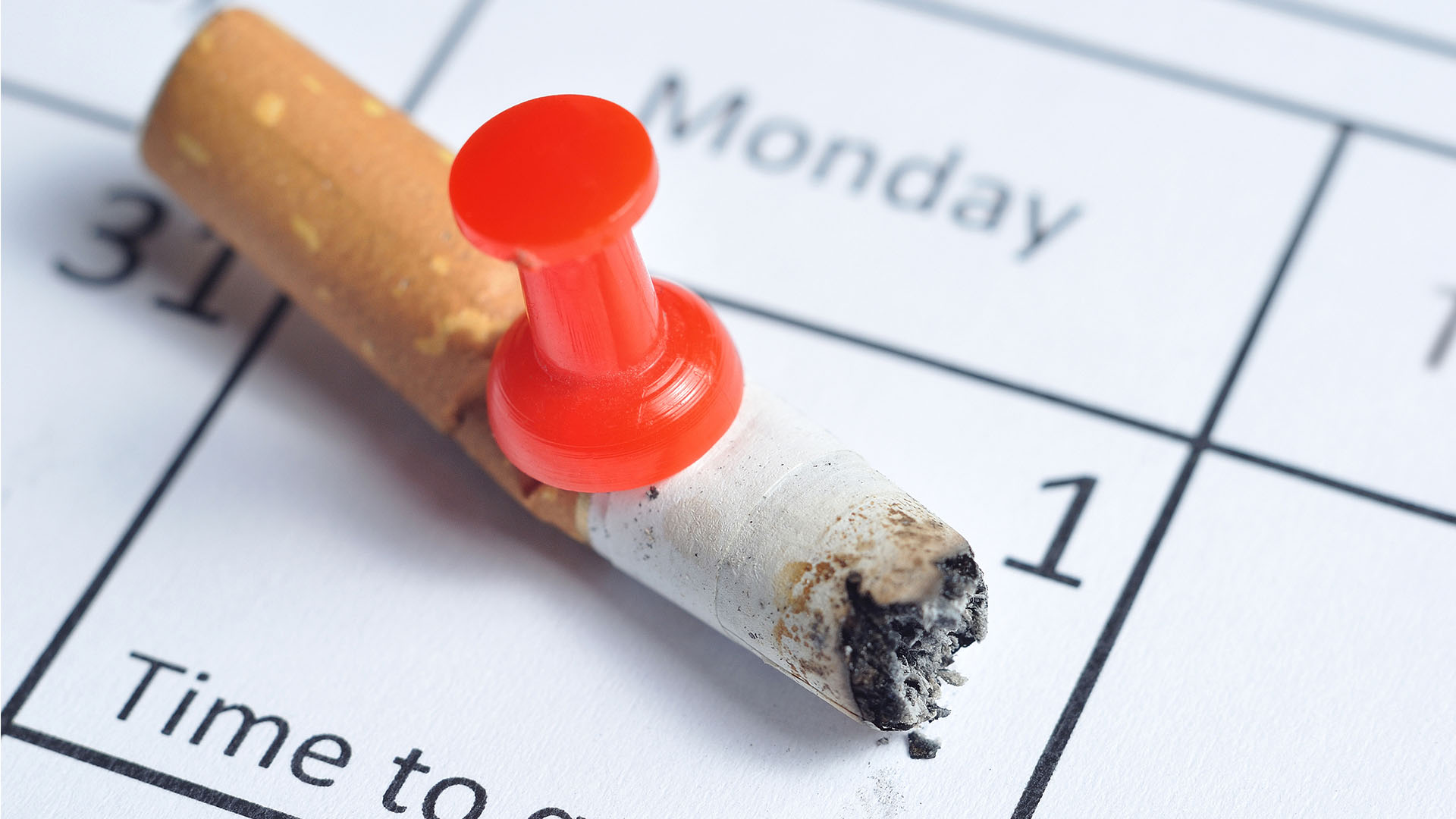 Zigarette, in der Pinnnadel steckt, Kalender mit: Time to quit.