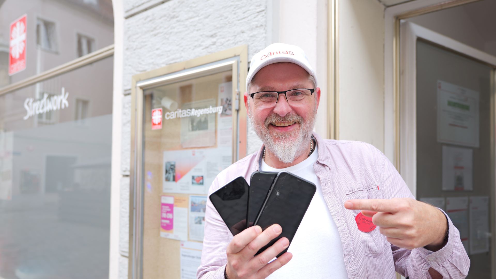 Christian Hierold hält gebrauchte Smartphones hoch.