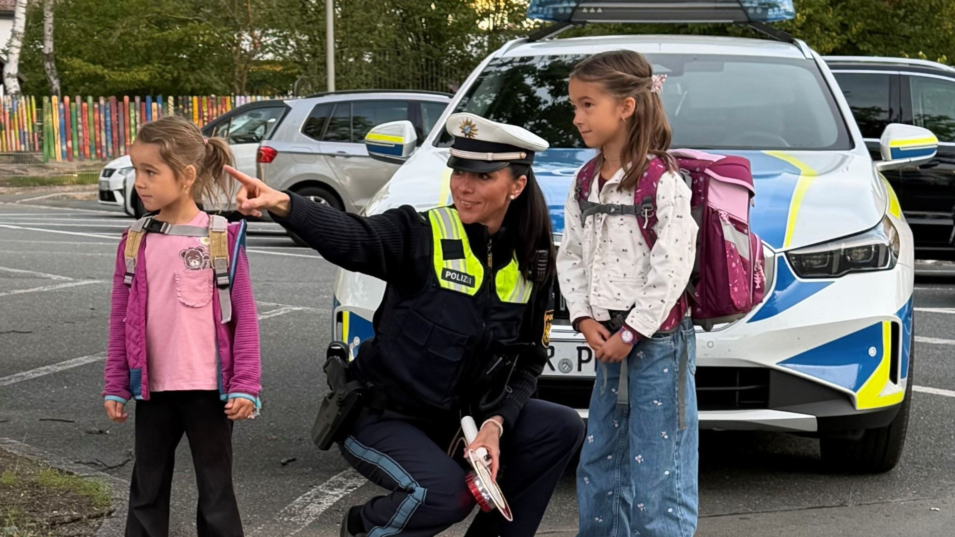 Eine Polizistin mit zwei Schulkindern