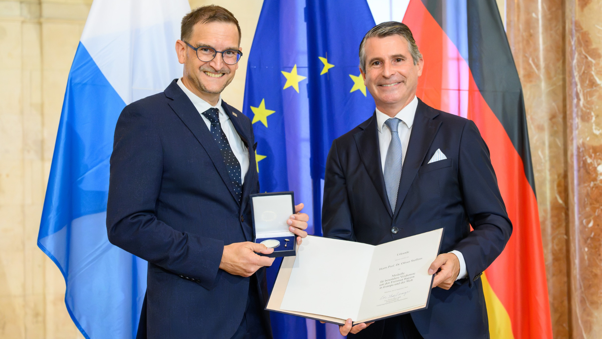 Bayerns Europaminister Eric Beißwenger (rechts) überreicht die Europamedaille an Prof. Dr. Oliver Steffens, Vizepräsident für Forschung und Internationales der OTH Regensburg