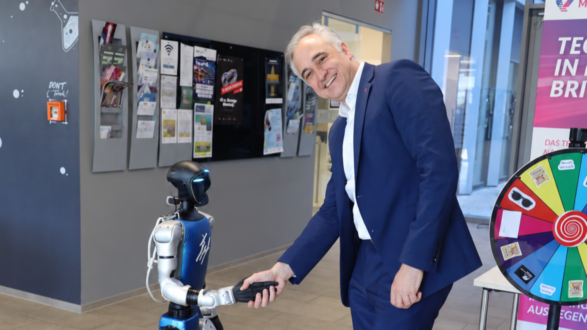 Thomas Burger schüttelt Roboter Hand