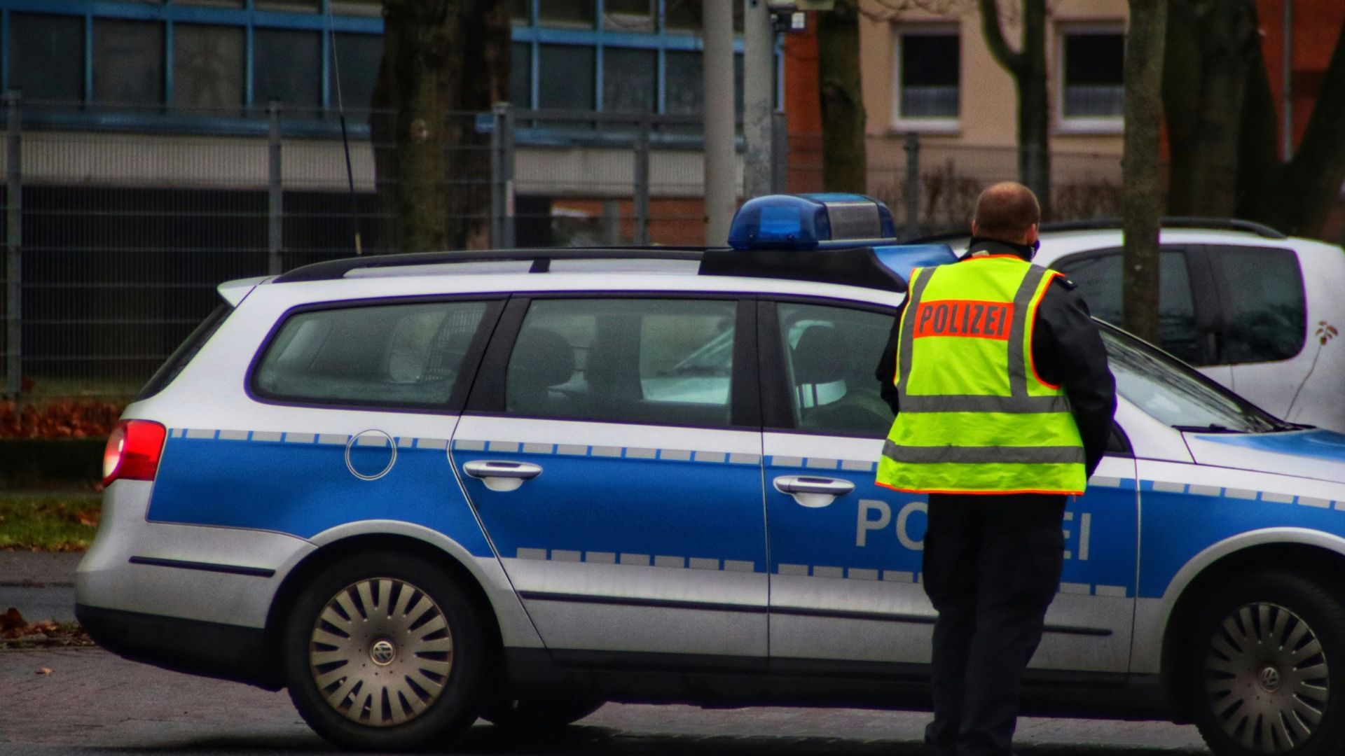 Polizist neben Polizeiauto